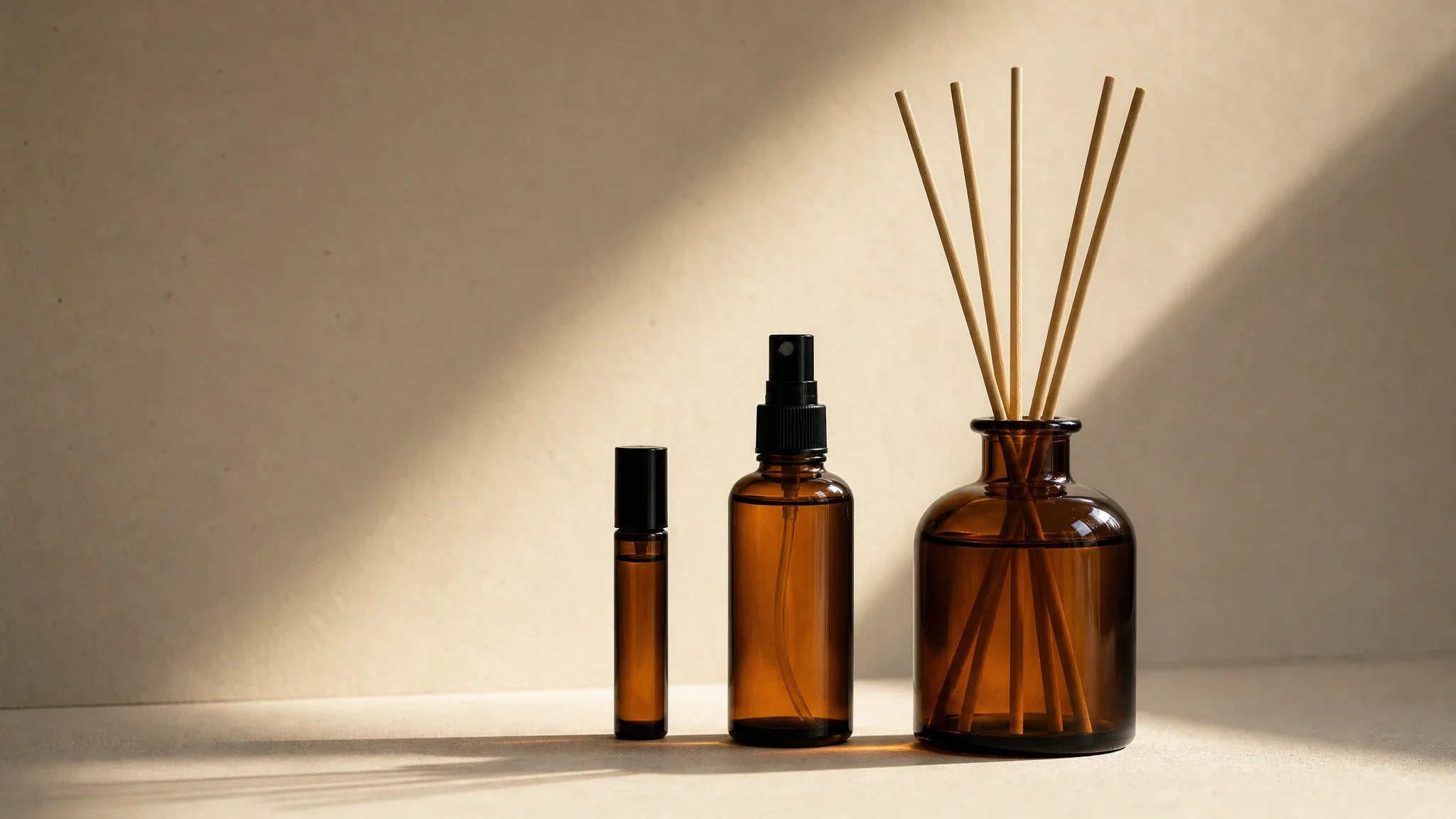 Drei Bernsteinglas-Formate von hinten: Roll-On, Fabric Spray, Reed Diffuser